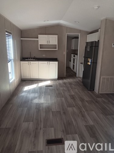 A kitchen with wooden floors and white cabinets.