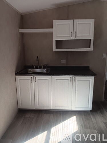 A kitchen with white cabinets and a black countertop.