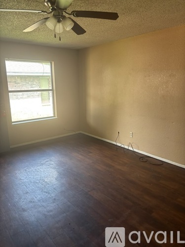 A room with a ceiling fan and a window.