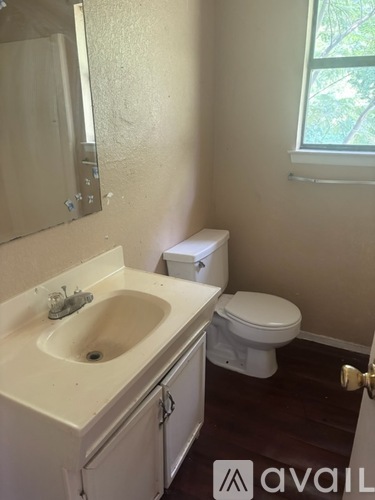 A bathroom with a sink, toilet and mirror.