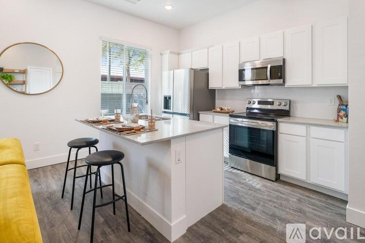 A kitchen with white cabinets and a wooden floor.