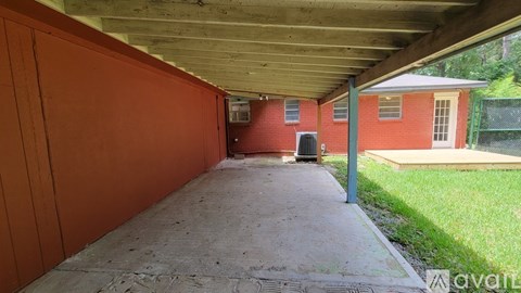 A covered walkway leads to a red brick building.