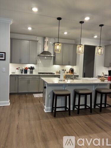 A spacious room with a ceiling fan and hardwood flooring.