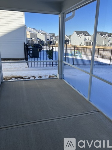 A view from inside a house looking out to a pool and other houses.