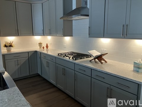 A modern kitchen with a stove top oven and a range hood.