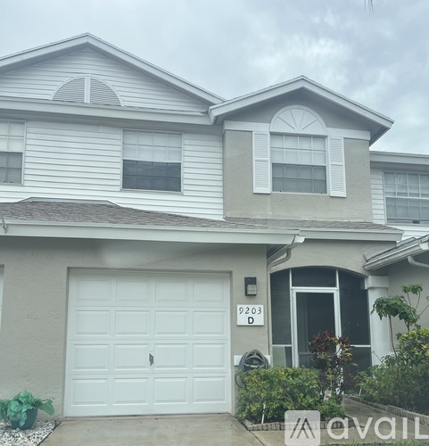 A two-story house with a garage and a window with shutters.