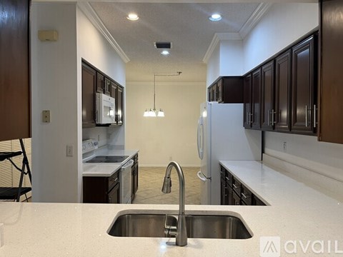 A kitchen with a sink and a refrigerator.