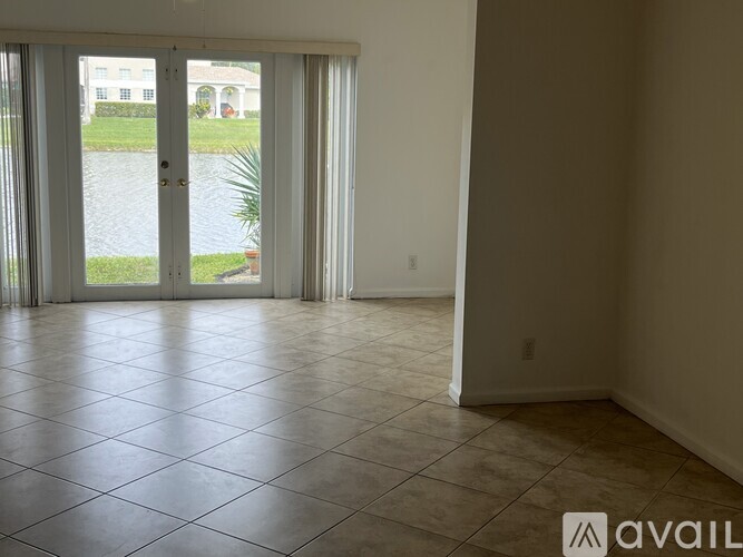A room with tiled flooring and a sliding glass door leading to a balcony.