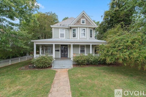 A house with a front yard and a walkway leading to the front door.