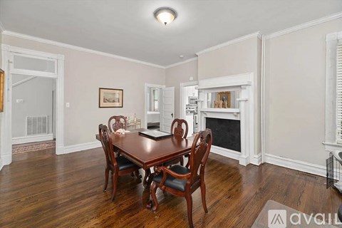 A dining room with a wooden table and chairs.