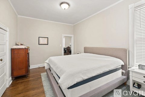 A bedroom with a bed, dresser, and nightstand.