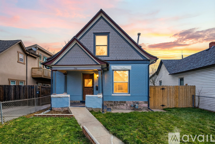 A blue house with a white fence in front of it.