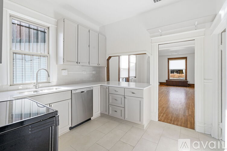 A kitchen with white cabinets and a black dishwasher.