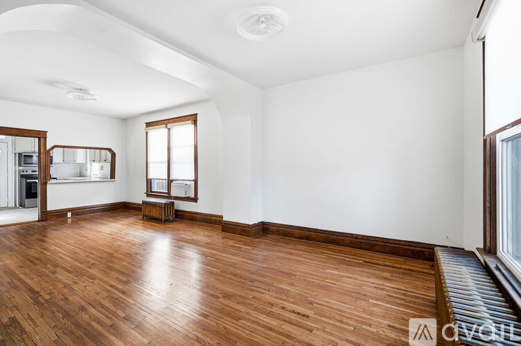 A spacious room with wooden floors and white walls.