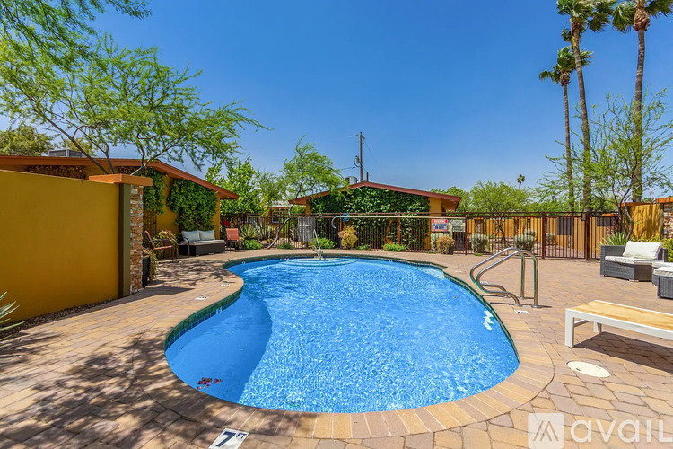 A pool surrounded by a wooden deck and patio furniture.