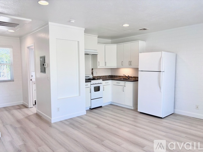 A kitchen with white appliances and cabinets.