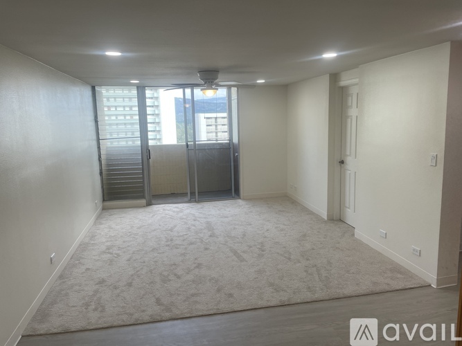 A spacious room with a carpeted floor and a ceiling fan.