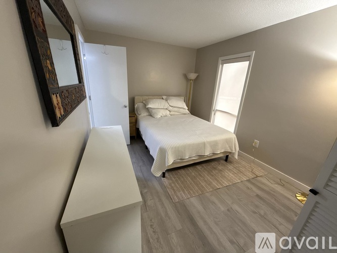 A bedroom with a bed, dresser, and mirror.