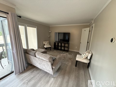 A living room with a grey sofa and a television.