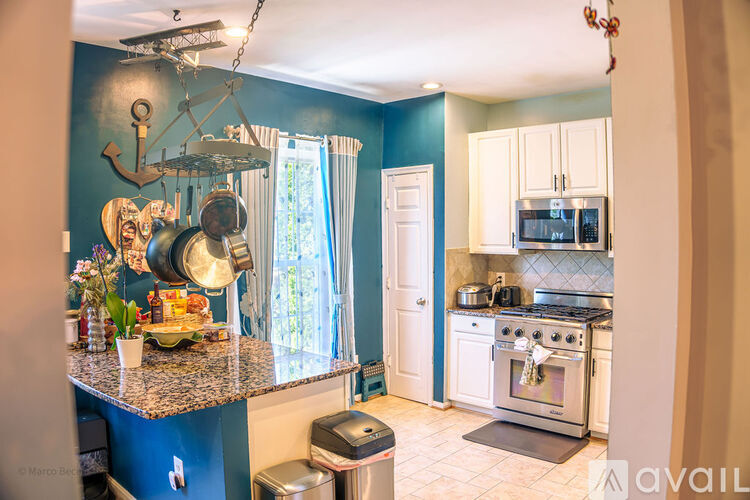A kitchen with a blue wall and a stove top oven.