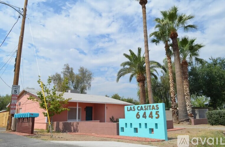 A sign in front of a house that says "Las Casitas 6445".