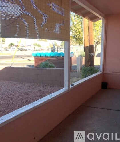 A window with a view of a blue object and trees.