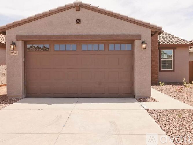 A house with a brown garage door and a driveway in front.