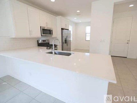 A kitchen with white cabinets and a white countertop.