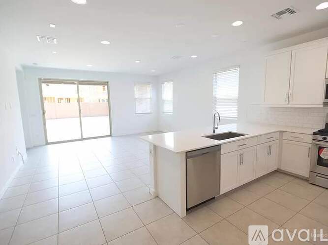 A spacious kitchen with white cabinets and a central island.