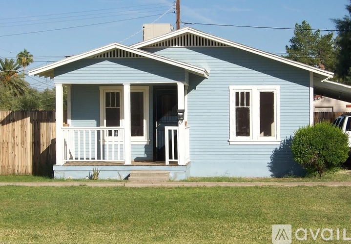 A blue house with a white porch and a white door.