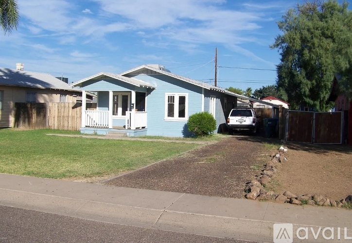 A blue house with a white van parked in front.