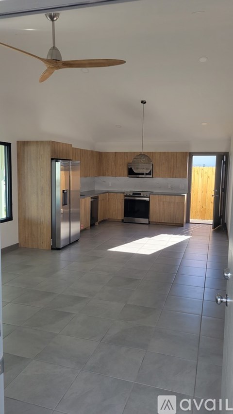 A modern kitchen with a fan and a dining area.