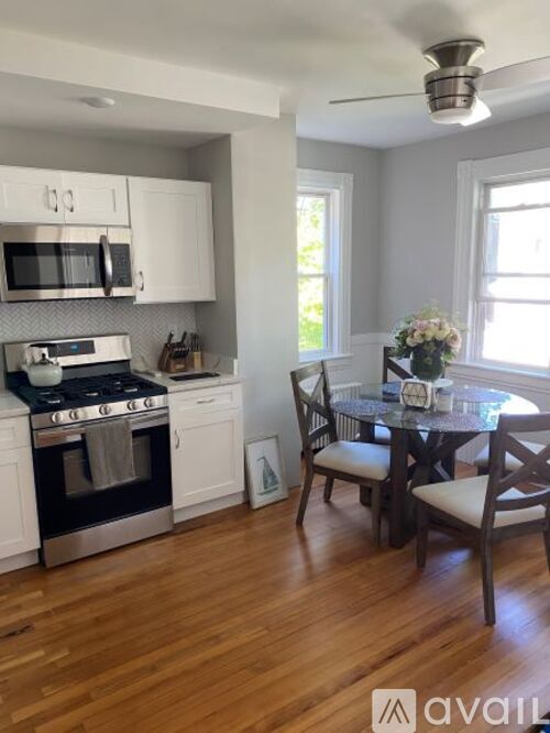 A kitchen with white cabinets and a black stove top oven.