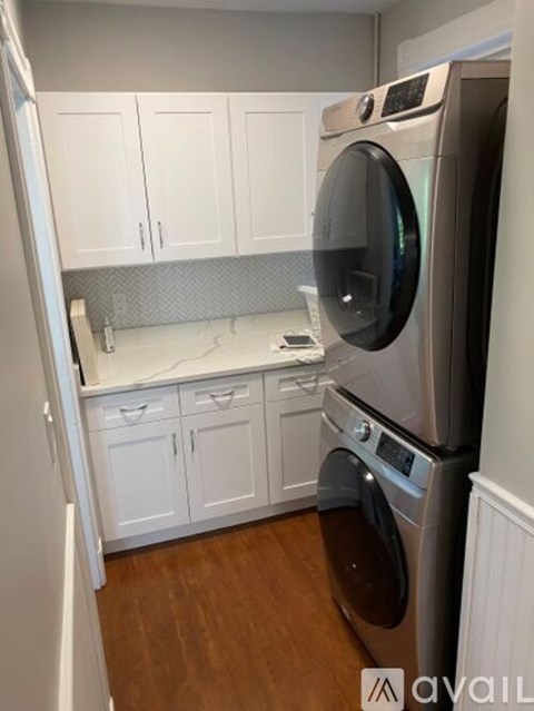A modern kitchen with a washing machine built into the cabinetry.