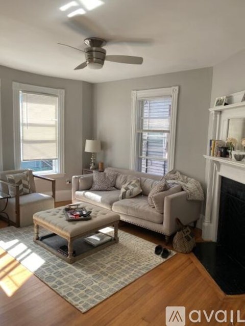 A living room with a grey couch, a coffee table, and a fireplace.