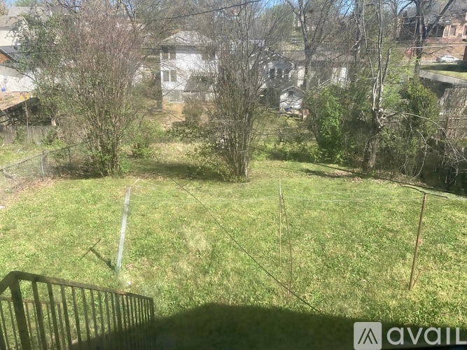 A grassy area with trees and a fence in the foreground.