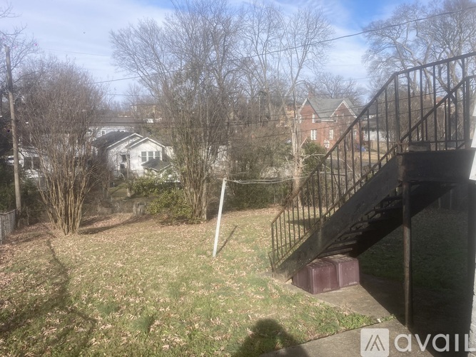 A backyard with a metal fence and a house in the background.