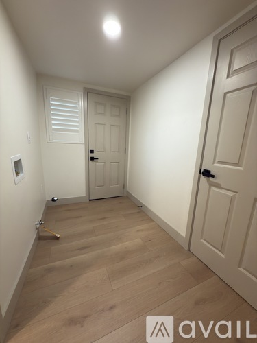 A hallway with wooden floors and white doors.