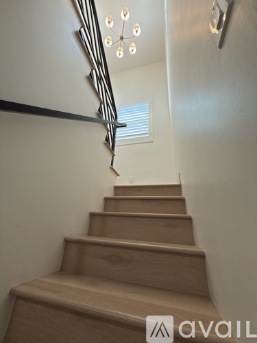 A staircase with wooden steps and a metal handrail.