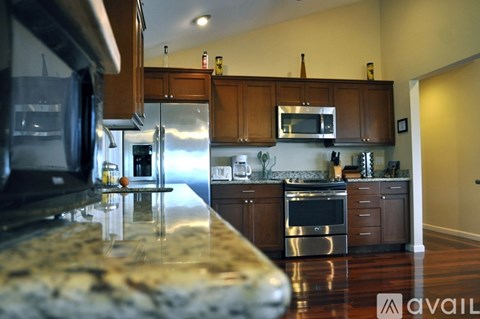 A kitchen with a granite counter top and stainless steel appliances.