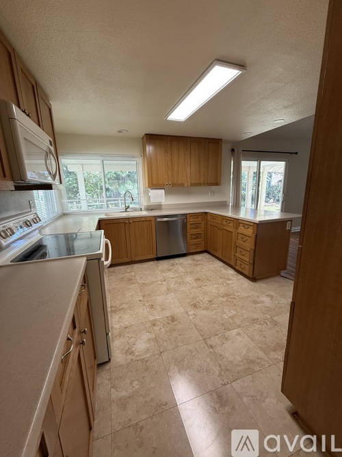 A kitchen with wooden cabinets and a tiled floor.