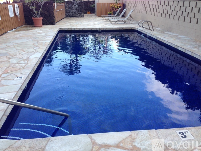A pool with a ladder and a stone border.