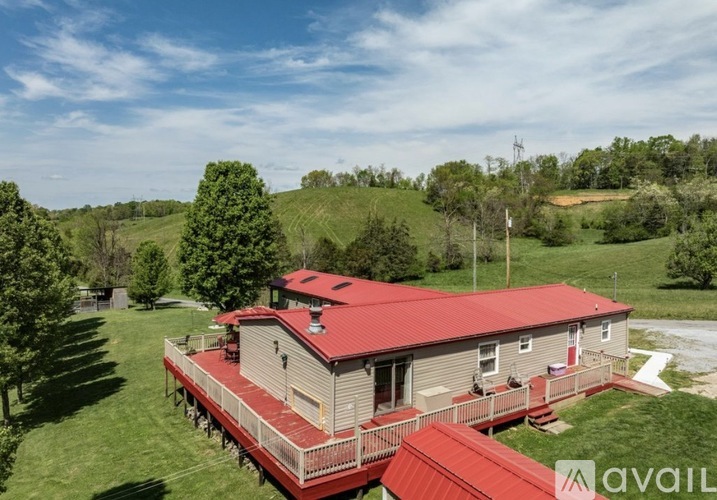 A house with a red roof is surrounded by greenery.