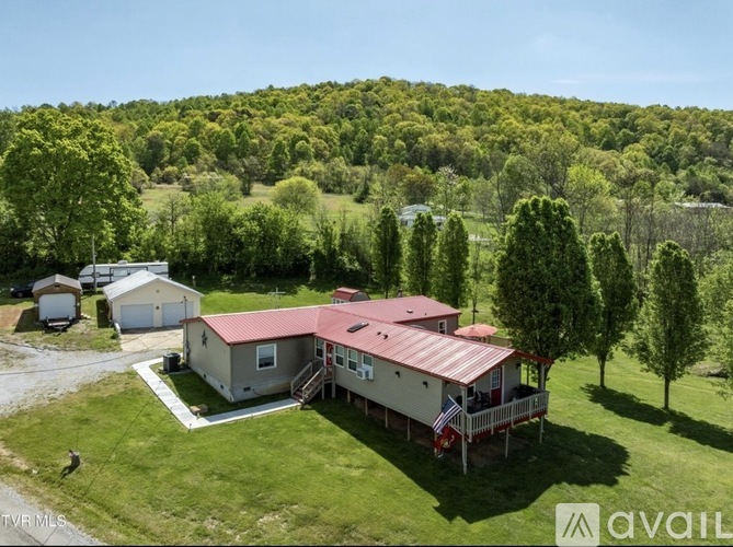 A house with a red roof is surrounded by greenery.