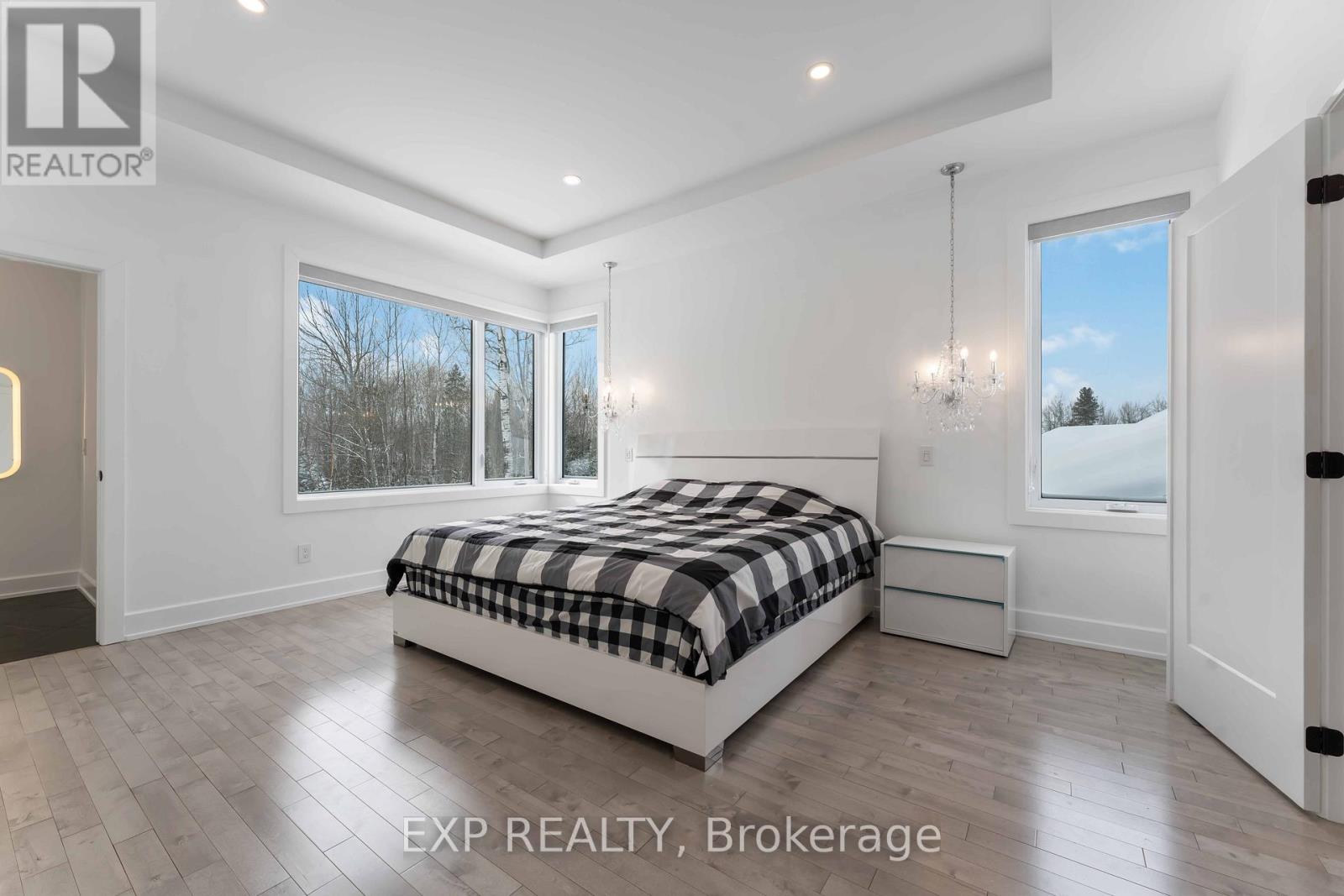 A bedroom with a large bed and a view of the outdoors through the window.