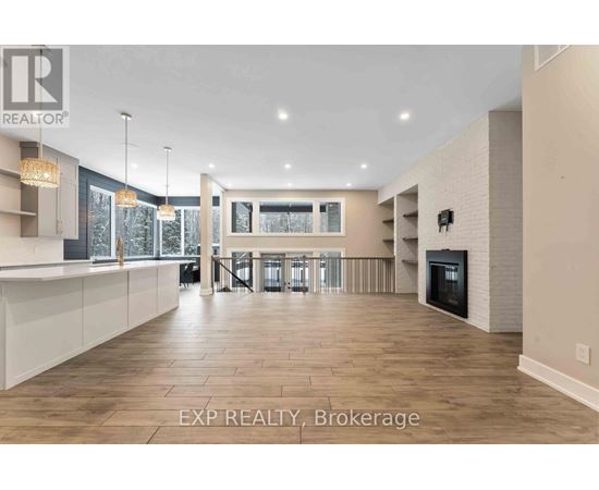 A spacious living room with a fireplace and a dining area with a table and chairs.