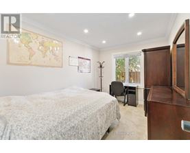 A bedroom with a world map on the wall and a bed with a white comforter.