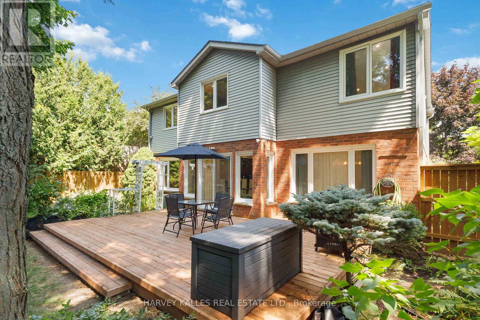 A backyard with a hot tub and deck.