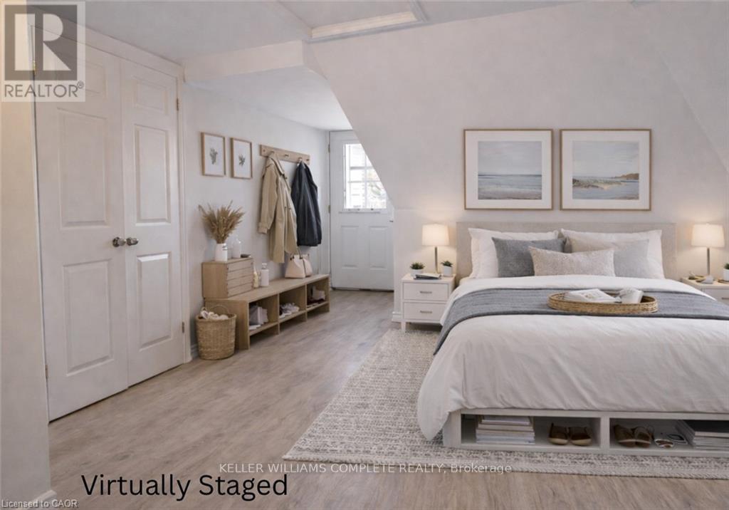 A bedroom with a bed, nightstands, and a coat rack.