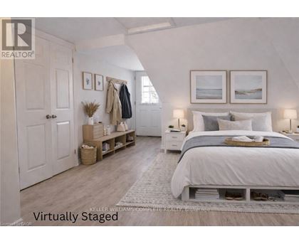 A bedroom with a bed, nightstands, and a coat rack.